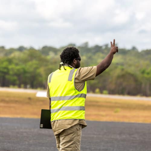 A man displaying the number two on a runway at the Iron Range Airport.